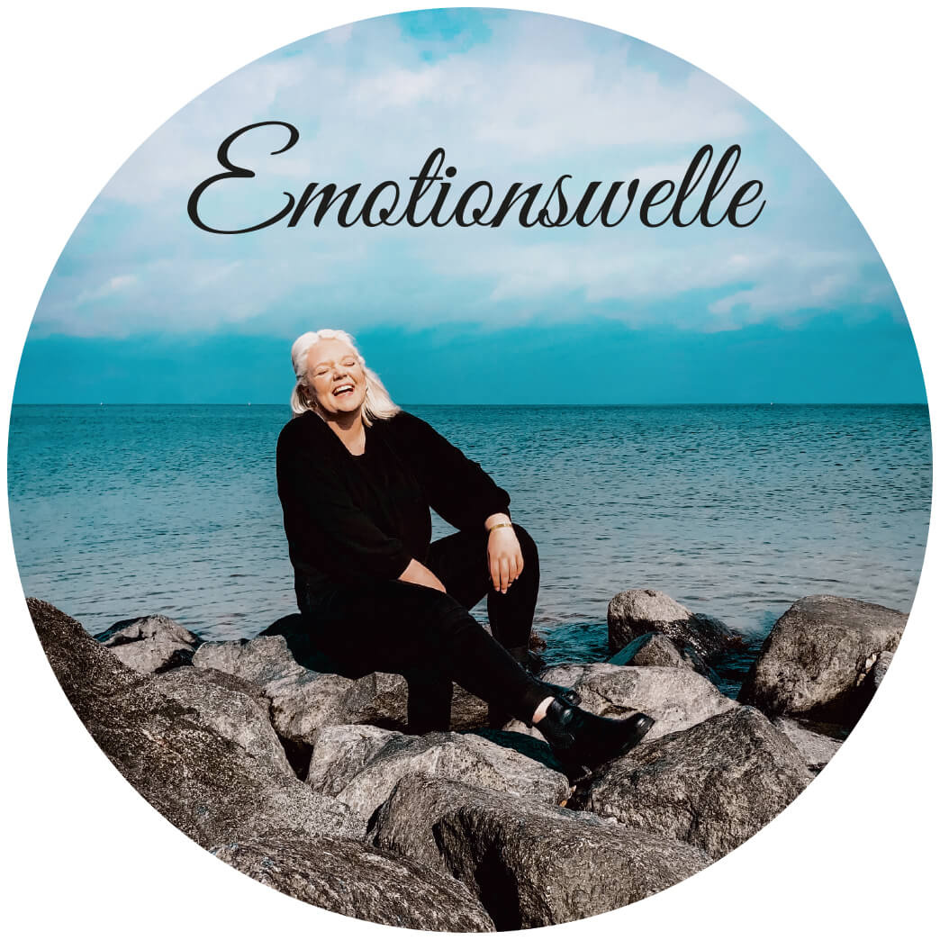 Bestattungshaus Frank | Lea Frank an steinger Meeresküste sitzend mit Schriftzug Emotionswelle als Kreis